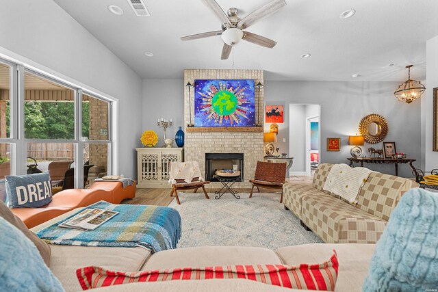 living area featuring recessed lighting, visible vents, wood finished floors, a fireplace, and ceiling fan with notable chandelier