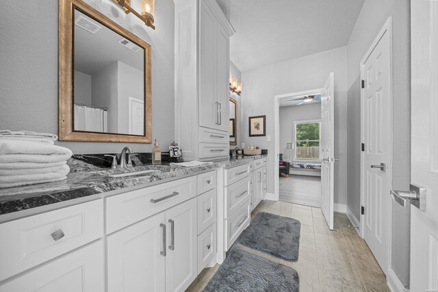 bathroom with visible vents, a sink, ensuite bath, and double vanity