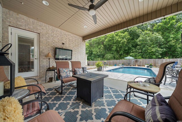 view of pool with a fenced backyard, a fire pit, a ceiling fan, a fenced in pool, and a patio area