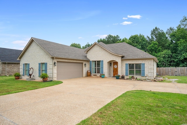 single story home featuring a garage, a shingled roof, concrete driveway, fence, and a front yard