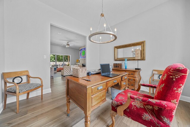 office with baseboards, light wood finished floors, and ceiling fan with notable chandelier