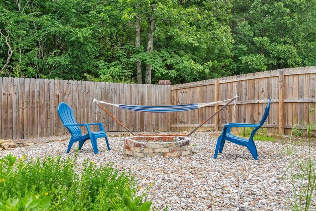 exterior space featuring a fenced backyard and a fire pit