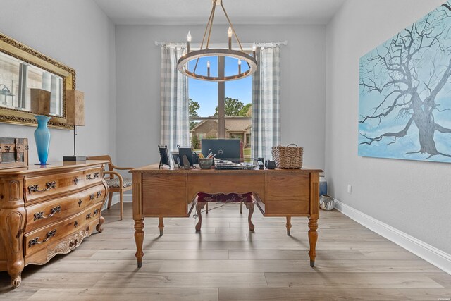 office area with a chandelier, baseboards, and light wood-style floors