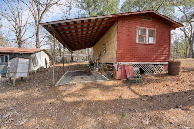 view of outdoor structure featuring a carport and dirt driveway