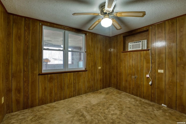 carpeted empty room with a textured ceiling, ceiling fan, a wall unit AC, and wooden walls