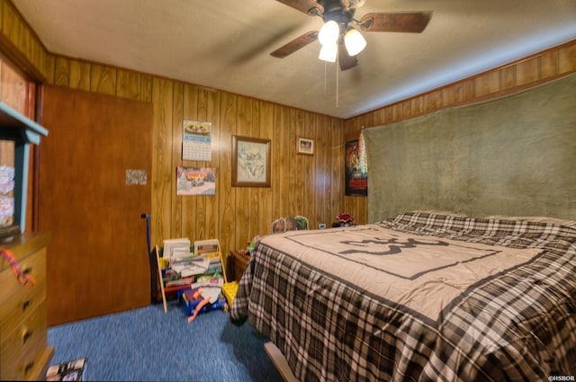 bedroom with carpet floors, wood walls, and a ceiling fan