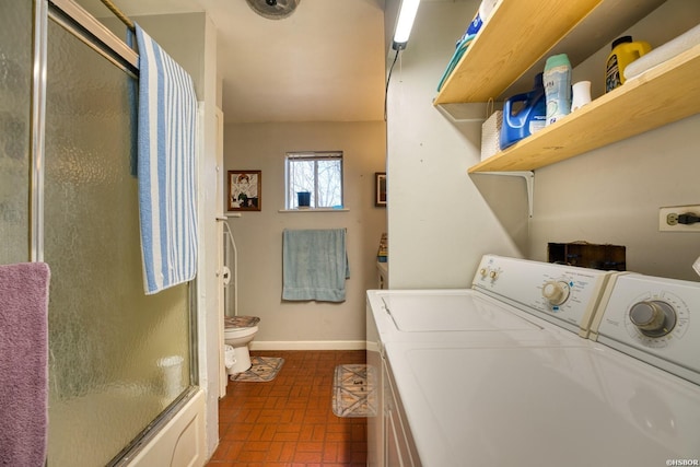 washroom featuring laundry area, separate washer and dryer, brick floor, and baseboards