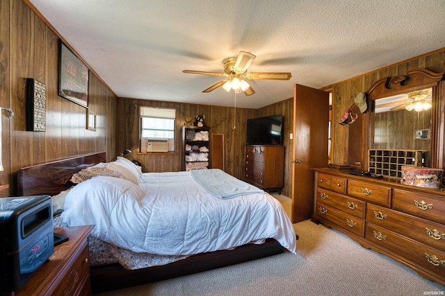 bedroom featuring wood walls, a textured ceiling, a ceiling fan, and carpet flooring