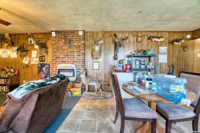 dining room featuring a textured ceiling, wood walls, and a fireplace