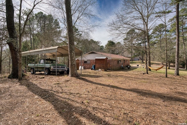 exterior space featuring a carport and dirt driveway