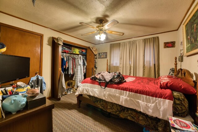 bedroom with a textured ceiling, carpet flooring, a ceiling fan, and crown molding