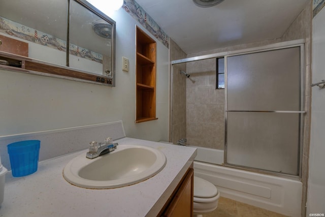 full bath featuring toilet, bath / shower combo with glass door, and vanity