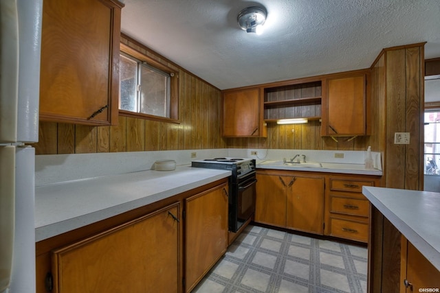 kitchen featuring black range with electric cooktop, light floors, light countertops, brown cabinets, and open shelves