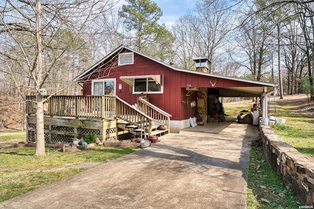 view of front facade with a deck, driveway, a carport, and a chimney