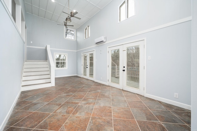 734 Randall Rd, Hot Springs, AR 71913 - unfurnished living room with french doors, an AC wall unit, a high ceiling, ceiling fan, and baseboards