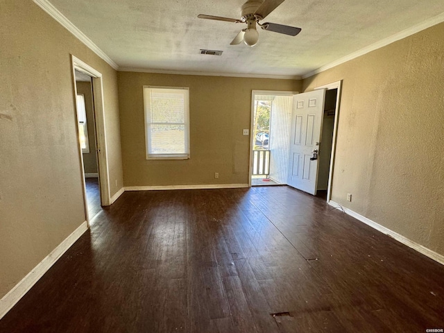 spare room with dark wood-style floors, a textured ceiling, baseboards, and crown molding