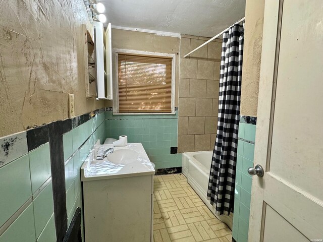 bathroom featuring shower / bath combination with curtain, tile walls, and vanity