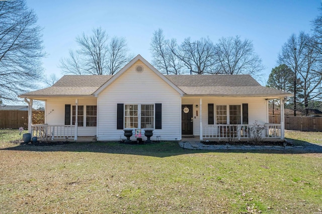 ranch-style house featuring a front lawn, fence, covered porch, and a shingled roof