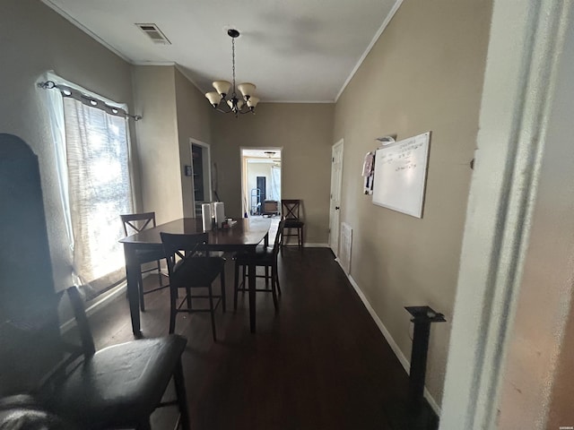 dining room featuring visible vents, baseboards, dark wood-style flooring, an inviting chandelier, and crown molding