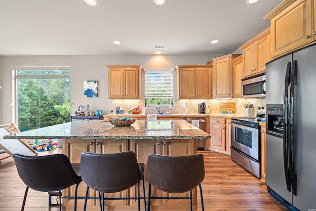 180 Port Au Prince, Hot Springs, AR 71913 - kitchen with stainless steel appliances, light brown cabinets, a kitchen island, recessed lighting, and a breakfast bar area