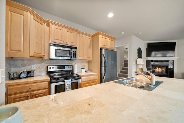 180 Port Au Prince, Hot Springs, AR 71913 - kitchen with stainless steel appliances, a sink, backsplash, a fireplace, and light brown cabinets