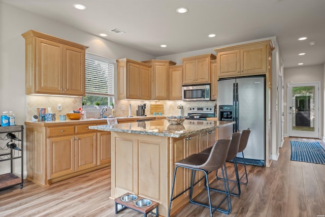 180 Port Au Prince, Hot Springs, AR 71913 - kitchen with appliances with stainless steel finishes, light wood-type flooring, recessed lighting, a center island, and tasteful backsplash