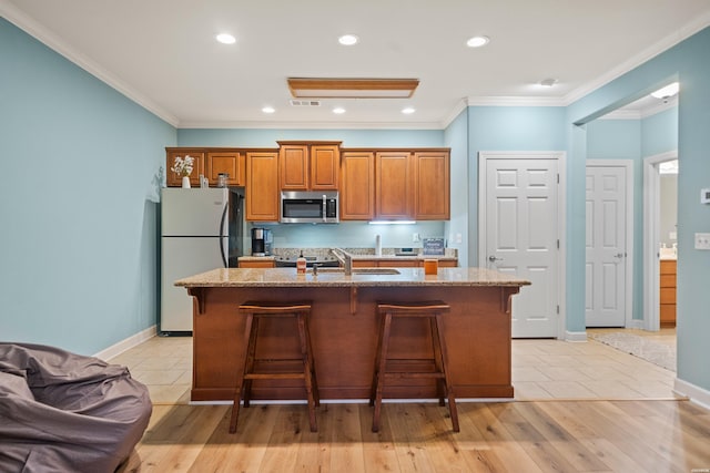 640 Arkridge Rd Unit D6, Hot Springs, AR 71913 - kitchen with stainless steel microwave, freestanding refrigerator, a kitchen breakfast bar, brown cabinetry, and ornamental molding