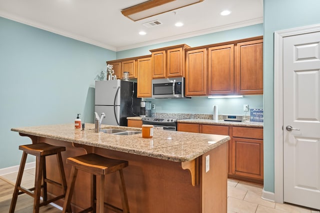 640 Arkridge Rd Unit D6, Hot Springs, AR 71913 - kitchen with appliances with stainless steel finishes, an island with sink, a breakfast bar area, brown cabinets, and ornamental molding