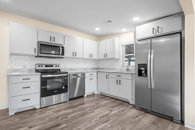 196 Morphew Rd, Hot Springs, AR 71913 - kitchen with stainless steel appliances, light wood-style flooring, decorative backsplash, a sink, and recessed lighting