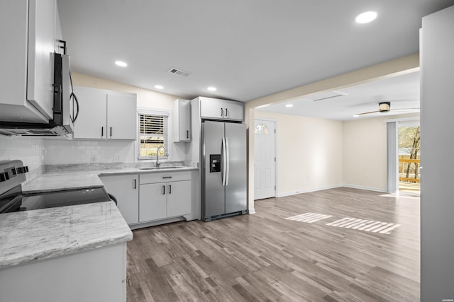 196 Morphew Rd, Hot Springs, AR 71913 - kitchen featuring appliances with stainless steel finishes, a sink, tasteful backsplash, light wood finished floors, and ceiling fan