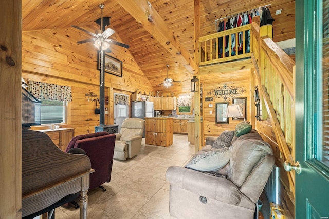 273 Alydar Trl, Hot Springs, AR 71901 - living room featuring healthy amount of natural light, ceiling fan, a wood stove, wood walls, and a wooden ceiling with exposed beams
