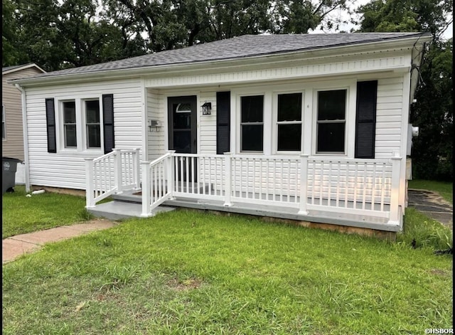 bungalow with a shingled roof and a front lawn