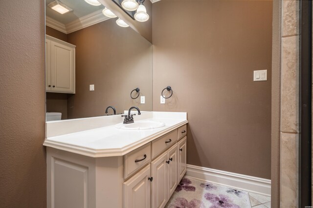 bathroom featuring ornamental molding, vanity, baseboards, and tile patterned floors