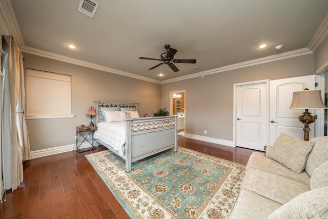 bedroom with baseboards, visible vents, dark wood finished floors, and crown molding