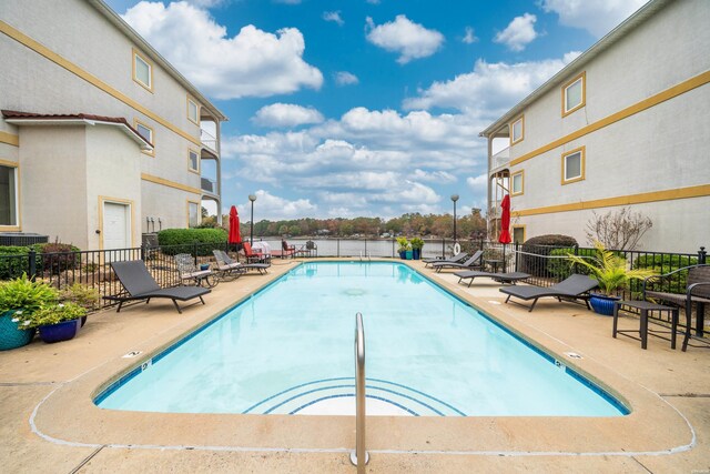 community pool with a patio area and fence