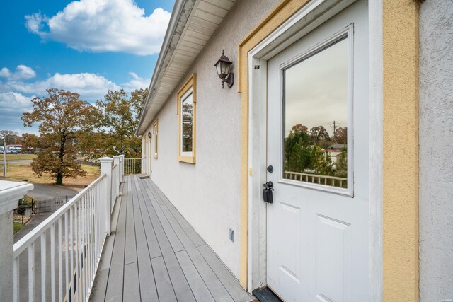 entrance to property featuring a balcony and stucco siding