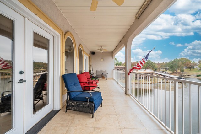 balcony featuring a water view, a sunroom, ceiling fan, and french doors