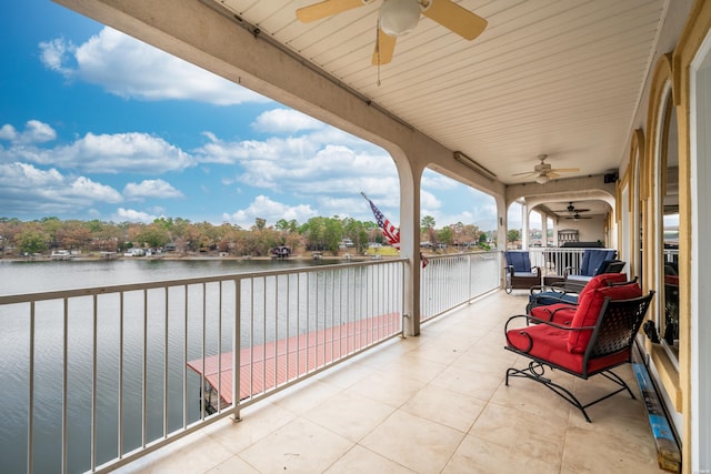 view of patio with a water view, a balcony, and a ceiling fan