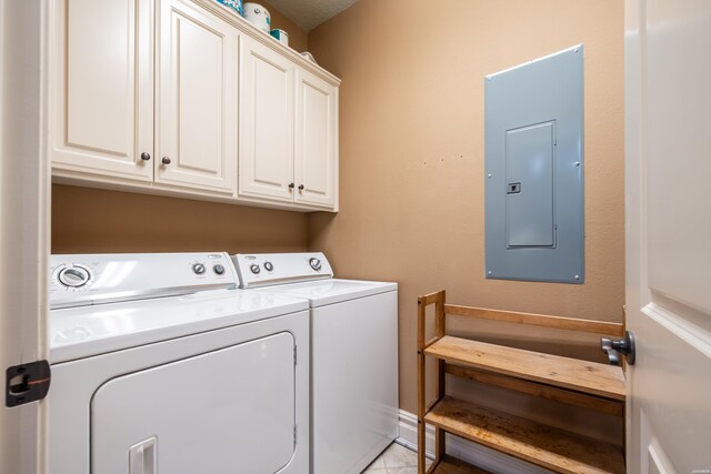 laundry area featuring electric panel, cabinet space, and washer and clothes dryer