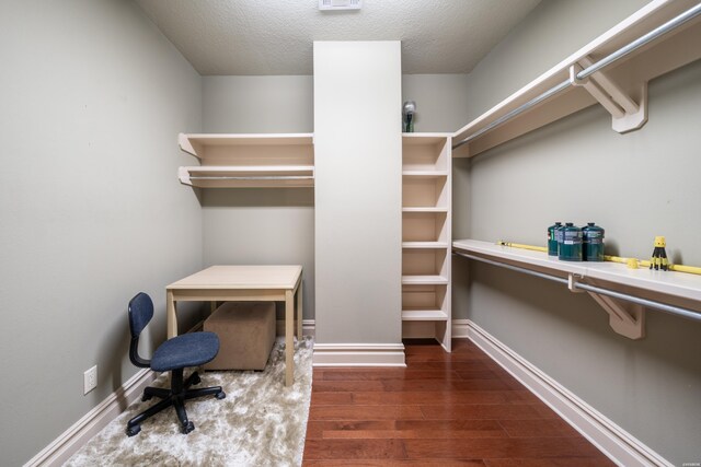 office area with dark wood-style floors, a textured ceiling, visible vents, and baseboards