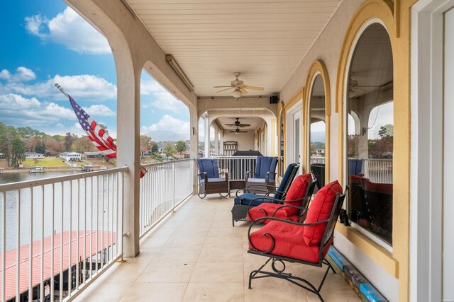 balcony with a water view and ceiling fan