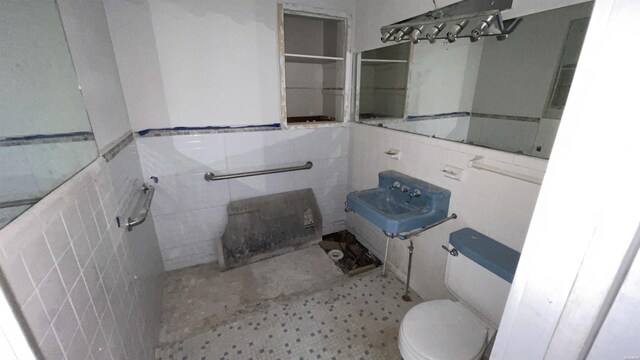 bathroom with toilet and tile walls