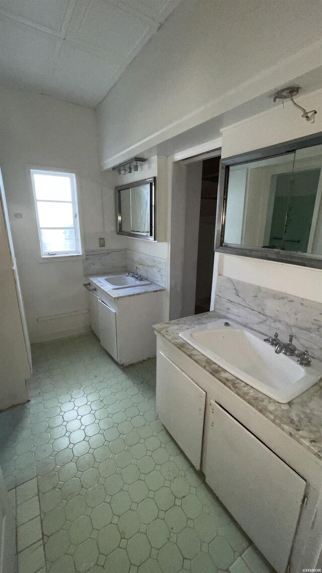 full bathroom featuring two vanities and a sink