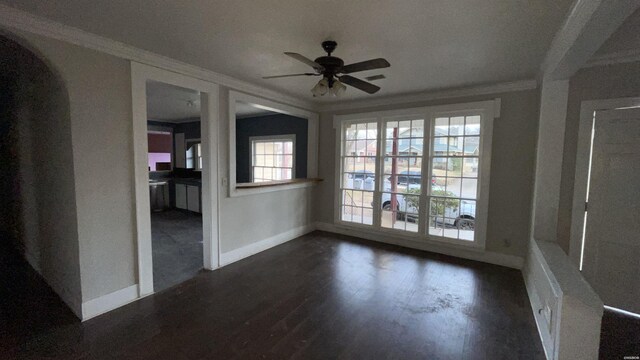 spare room with ceiling fan, baseboards, ornamental molding, and dark wood finished floors