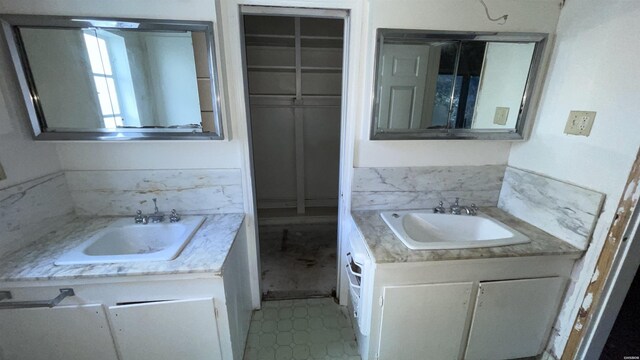 bathroom with a spacious closet and vanity