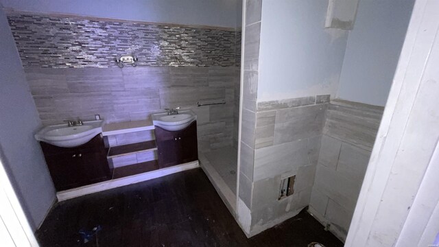 full bath with vanity, tile walls, and a shower stall