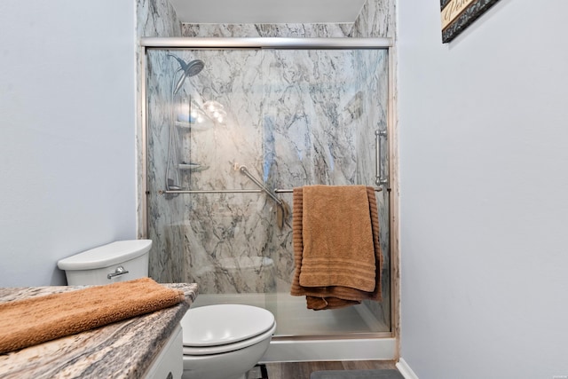 full bath featuring a marble finish shower, vanity, and toilet