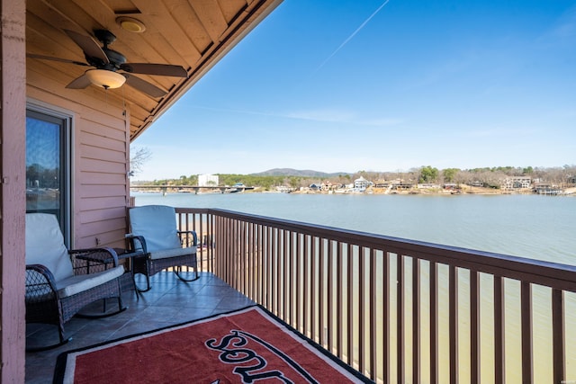 balcony featuring a water view and ceiling fan