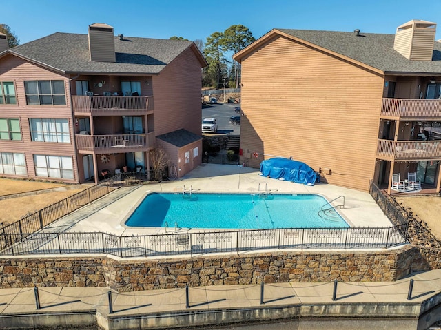 community pool featuring a patio area and fence