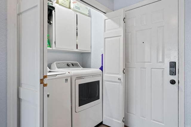 laundry area featuring washing machine and dryer and cabinet space